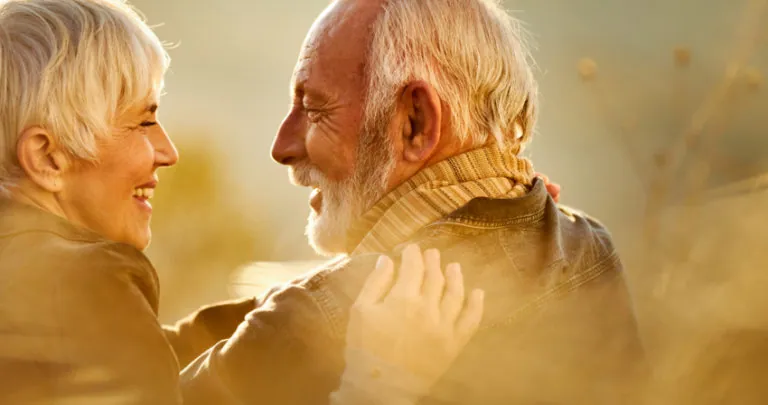 Happy older couple enjoying a sunset